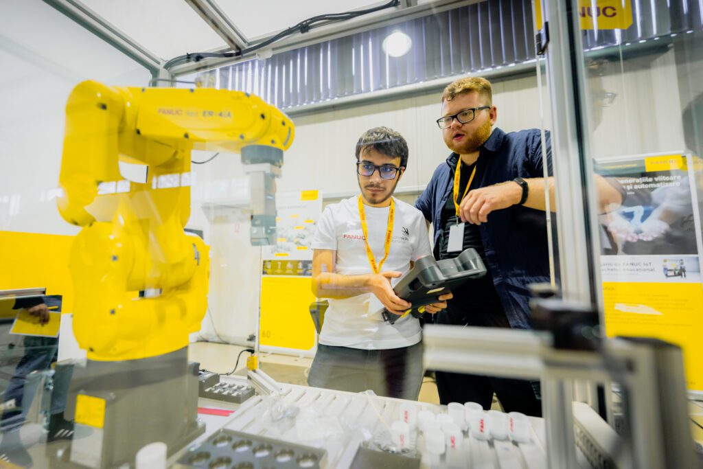 FANUC și WorldSkills au demarat o olimpiadă de integrare de roboți industriali Doi studenți din Cluj-Napoca vor reprezenta România la Olimpiada Europeană de Meserii EuroSkills 2023, secțiunea integrare de sisteme de roboți. FANUC și WorldSkills România au organizat prima ediție a Olimpiadei Naționale FANUC WorldSkills de Integrare de Roboți Industriali pentru tinerii români. Patru echipe de studenți de la universitățile tehnice din țară au concurat la Cluj-Napoca în 26-27 aprilie. Echipa câștigătoare va reprezenta România la categoria integrare de sisteme de roboți în cadrul Olimpiadei Europene de Meserii EuroSkills Gdansk 2023, organizate în Polonia, în septembrie. Începutul anului a fost unul solicitant pentru studenții departamentelor de robotică din cadrul a patru instituții e învățământ superior: Universitatea Tehnică Lucian Blaga din Sibiu, Universitatea Tehnică Gheorghe Asachi din Iași, Universitatea Politehnică din București și Universitatea Tehnică din Cluj-Napoca. Ei au participat la cursuri și probe de preselecție în vederea calificării la prima ediție a Olimpiadei Naționale FANUC WorldSkills de Integrare de Roboți Industriali, organizată în România în primăvară, la sediul FANUC România, de lângă Cluj-Napoca. Cele patru echipe finaliste, alcătuite fiecare din câte doi studenți și un cadru didactic îndrumător, s-au întrecut timp de două zile, în patru probe de concurs, desfășurate exclusiv în limba engleză, în a-și demonstra abilitățile și cunoștințele de programare și utilizare a roboților industriali. Concursul, organizat în parteneriat de câtre FANUC România și Fundația WorldSkills România, are ca obiectiv pe termen lung aprofundarea cunoștințelor, abilităților și experienței practice ale studenților din universitățile tehnice românești în programarea și integrarea roboților industriali în perspectiva dezvoltării unei cariere profesionale într-un domeniu de foarte mare actualitate. Echipa câștigătoare va fi înscrisă ca reprezentantă din partea României la proba de integrare de sisteme de roboți de la EuroSkills Gdansk 2023. Membrii echipei câștigătoare sunt studenți în anul IV la Universitatea Tehnică din Cluj-Napoca (UTCN), Facultatea de Inginerie Industrială, Robotică și Managementul Producției. ,,Sarcina principală de lucru din cadrul compeției era un proces preluat din industrie. Așadar, a implicat toate detaliile tehnice precum electronică, modelare layout în RoboGuide, programare, instalarea echipamentelor și altele. A fost o experință foarte bună, fiindcă am avut ocazia să punem în practică ceea ce am studiat la facultate. Fiindcă exercițiul pricipal al compentiției a fost unul realist și ne-am aflat permanent sub presiunea timpului, consider că ne va ajuta enorm de mult în cariera noastră de roboticieni”, a spus Kántor Jozsue, membru al echipei câștigătoare. ,,Cel mai dificil a fost să lucrăm după standardele europene, enorm de stricte din toate punctele de vedere. Multitudinea de cerințe a generat o colaborare bună între noi. Fără lucrul în echipă nu am fi reușit o asemenea performanță”. a menționat Krasznai Györk Attila, celălalt membru al echipei câștigătoare. Aflându-se la prima ediție, experții români și organizatorii au primit sprijinul expertului britanic de origine română în integrare de sisteme de roboți Karla Kosch. Ea a participat la Olimpiadă în calitate de președinte al juriului. ,,Prima Olimpiada Națională de Integrare de Roboți Industriali desfășurată la Cluj-Napoca a dezvăluit talente din patru mari universități. Munca depusă cu dedicație de echipele de studenți din Cluj, București, Sibiu și Iași a fost cu atât mai evidentă cu cât concursul a fost susținut în limba engleză. E un pas îndrăzneț și lăudabil care aduce România cu un pas mai aproape de competițiile internaționale. Felicitări organizatorilor - FANUC România și WorldSkills România - pentru această inițiativă unica și mult succes la EuroSkills Gdansk în septembrie 2023”, a spus Karla Kosch, lector în inginerie la Northern Regional College, Irlanda de Nord. În timp ce automatizarea industrială și robotizarea au devenit soluții preferate de producătorii industriali pentru sporirea competitivității și a performanței, multe companii se confruntă cu o criză a lucrătorilor calificați. Prin astfel de parteneriate și implicarea în proiecte educaționale, FANUC oferă oportunități noilor generații în a învăța tot mai mult și a se specializa în domeniile de interes. Corporația FANUC este unul dintre liderii mondiali în automatizarea fabricilor pentru sisteme de control CNC, roboți și mașini de producție (Robodrill, Robocut și Roboshot). Din 1956, este pionier în dezvoltarea mașinilor cu comandă numerică în industria automatizării. Cu 266 de locații FANUC în întreaga lume și 8.000 de angajați, FANUC oferă o rețea densă de vânzări, suport tehnic, cercetare și dezvoltare, logistică și servicii pentru clienți. FANUC România este subsidiara locală a organizației FANUC și are sediul principal în Cluj-Napoca. Din 2018, FANUC, în calitate de producător de top de roboți industriali, a devenit partener global al WorldSkills International și facilitator în organizarea competițiilor naționale, europene și mondiale dedicate tinerilor integratori de roboți industriali. Organizația WorldSkills este recunoscută pentru contribuția sa de decenii în promovarea meseriilor în rândul tinerilor prin competiții organizate în întreaga lume. Misiunea sa globală este direcționată înspre trei zone de interes. Ele sunt să inspire tinerii în a-și urma pasiunea în viață; să dezvolte meserii prin specializări și concursuri standardizate; să atragă reprezentanți ai industriilor, organizațiilor guvernamentale și mediului academic pentru susținerea tinerilor. WorldSkills România susține performanța profesională în rândul tinerilor români prin afirmarea excelenței în domeniul profesional, crearea de experiențe de învățare relevante în diverse domenii profesionale, facilitarea colaborării cu organizații cheie din domeniile respective.