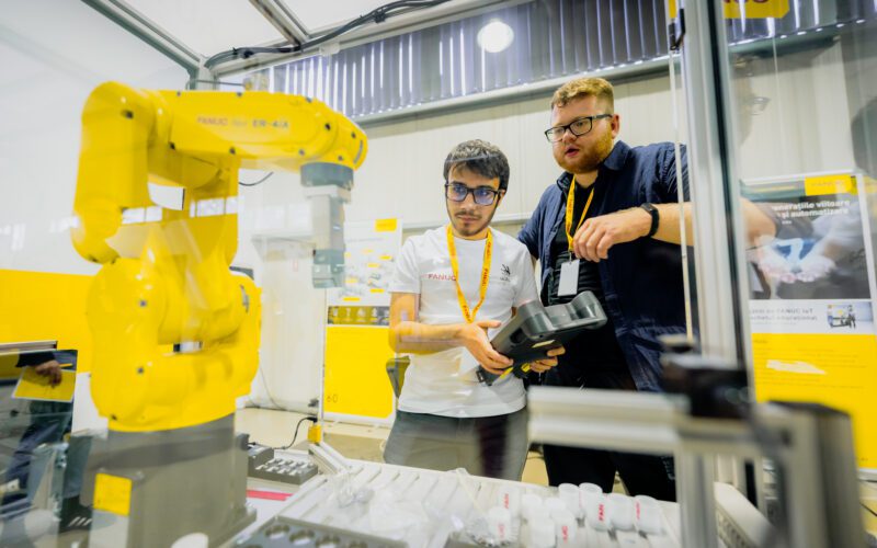 FANUC și WorldSkills au demarat o olimpiadă de integrare de roboți industriali Doi studenți din Cluj-Napoca vor reprezenta România la Olimpiada Europeană de Meserii EuroSkills 2023, secțiunea integrare de sisteme de roboți. FANUC și WorldSkills România au organizat prima ediție a Olimpiadei Naționale FANUC WorldSkills de Integrare de Roboți Industriali pentru tinerii români. Patru echipe de studenți de la universitățile tehnice din țară au concurat la Cluj-Napoca în 26-27 aprilie. Echipa câștigătoare va reprezenta România la categoria integrare de sisteme de roboți în cadrul Olimpiadei Europene de Meserii EuroSkills Gdansk 2023, organizate în Polonia, în septembrie. Începutul anului a fost unul solicitant pentru studenții departamentelor de robotică din cadrul a patru instituții e învățământ superior: Universitatea Tehnică Lucian Blaga din Sibiu, Universitatea Tehnică Gheorghe Asachi din Iași, Universitatea Politehnică din București și Universitatea Tehnică din Cluj-Napoca. Ei au participat la cursuri și probe de preselecție în vederea calificării la prima ediție a Olimpiadei Naționale FANUC WorldSkills de Integrare de Roboți Industriali, organizată în România în primăvară, la sediul FANUC România, de lângă Cluj-Napoca. Cele patru echipe finaliste, alcătuite fiecare din câte doi studenți și un cadru didactic îndrumător, s-au întrecut timp de două zile, în patru probe de concurs, desfășurate exclusiv în limba engleză, în a-și demonstra abilitățile și cunoștințele de programare și utilizare a roboților industriali. Concursul, organizat în parteneriat de câtre FANUC România și Fundația WorldSkills România, are ca obiectiv pe termen lung aprofundarea cunoștințelor, abilităților și experienței practice ale studenților din universitățile tehnice românești în programarea și integrarea roboților industriali în perspectiva dezvoltării unei cariere profesionale într-un domeniu de foarte mare actualitate. Echipa câștigătoare va fi înscrisă ca reprezentantă din partea României la proba de integrare de sisteme de roboți de la EuroSkills Gdansk 2023. Membrii echipei câștigătoare sunt studenți în anul IV la Universitatea Tehnică din Cluj-Napoca (UTCN), Facultatea de Inginerie Industrială, Robotică și Managementul Producției. ,,Sarcina principală de lucru din cadrul compeției era un proces preluat din industrie. Așadar, a implicat toate detaliile tehnice precum electronică, modelare layout în RoboGuide, programare, instalarea echipamentelor și altele. A fost o experință foarte bună, fiindcă am avut ocazia să punem în practică ceea ce am studiat la facultate. Fiindcă exercițiul pricipal al compentiției a fost unul realist și ne-am aflat permanent sub presiunea timpului, consider că ne va ajuta enorm de mult în cariera noastră de roboticieni”, a spus Kántor Jozsue, membru al echipei câștigătoare. ,,Cel mai dificil a fost să lucrăm după standardele europene, enorm de stricte din toate punctele de vedere. Multitudinea de cerințe a generat o colaborare bună între noi. Fără lucrul în echipă nu am fi reușit o asemenea performanță”. a menționat Krasznai Györk Attila, celălalt membru al echipei câștigătoare. Aflându-se la prima ediție, experții români și organizatorii au primit sprijinul expertului britanic de origine română în integrare de sisteme de roboți Karla Kosch. Ea a participat la Olimpiadă în calitate de președinte al juriului. ,,Prima Olimpiada Națională de Integrare de Roboți Industriali desfășurată la Cluj-Napoca a dezvăluit talente din patru mari universități. Munca depusă cu dedicație de echipele de studenți din Cluj, București, Sibiu și Iași a fost cu atât mai evidentă cu cât concursul a fost susținut în limba engleză. E un pas îndrăzneț și lăudabil care aduce România cu un pas mai aproape de competițiile internaționale. Felicitări organizatorilor - FANUC România și WorldSkills România - pentru această inițiativă unica și mult succes la EuroSkills Gdansk în septembrie 2023”, a spus Karla Kosch, lector în inginerie la Northern Regional College, Irlanda de Nord. În timp ce automatizarea industrială și robotizarea au devenit soluții preferate de producătorii industriali pentru sporirea competitivității și a performanței, multe companii se confruntă cu o criză a lucrătorilor calificați. Prin astfel de parteneriate și implicarea în proiecte educaționale, FANUC oferă oportunități noilor generații în a învăța tot mai mult și a se specializa în domeniile de interes. Corporația FANUC este unul dintre liderii mondiali în automatizarea fabricilor pentru sisteme de control CNC, roboți și mașini de producție (Robodrill, Robocut și Roboshot). Din 1956, este pionier în dezvoltarea mașinilor cu comandă numerică în industria automatizării. Cu 266 de locații FANUC în întreaga lume și 8.000 de angajați, FANUC oferă o rețea densă de vânzări, suport tehnic, cercetare și dezvoltare, logistică și servicii pentru clienți. FANUC România este subsidiara locală a organizației FANUC și are sediul principal în Cluj-Napoca. Din 2018, FANUC, în calitate de producător de top de roboți industriali, a devenit partener global al WorldSkills International și facilitator în organizarea competițiilor naționale, europene și mondiale dedicate tinerilor integratori de roboți industriali. Organizația WorldSkills este recunoscută pentru contribuția sa de decenii în promovarea meseriilor în rândul tinerilor prin competiții organizate în întreaga lume. Misiunea sa globală este direcționată înspre trei zone de interes. Ele sunt să inspire tinerii în a-și urma pasiunea în viață; să dezvolte meserii prin specializări și concursuri standardizate; să atragă reprezentanți ai industriilor, organizațiilor guvernamentale și mediului academic pentru susținerea tinerilor. WorldSkills România susține performanța profesională în rândul tinerilor români prin afirmarea excelenței în domeniul profesional, crearea de experiențe de învățare relevante în diverse domenii profesionale, facilitarea colaborării cu organizații cheie din domeniile respective.