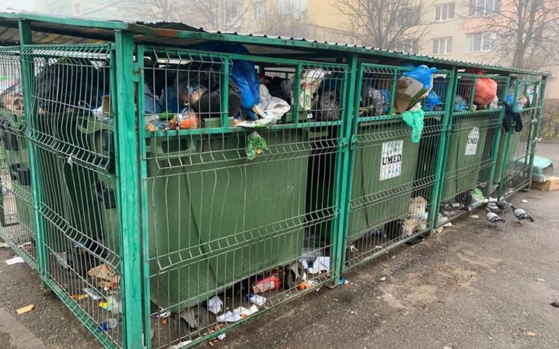 Haos în gestionarea deșeurilor în Baia Mare Amestecarea deșeurilor, depozitarea ilegală, lipsa facilităților pentru colectarea separată, deșeurile din construcții sunt principalele “scurtcircuite” Asociația Ecoteca și Primaria Baia Mare au organizat o masă rotundă pentru a discuta soluții de eficientizare a gestionării deșeurilor în județul Maramureș. Aceasta beneficiat de sprijinul organizațiilor GreenPoint Management, Envirom, Alucro, Ecotic și companiei Egger România. Printre participanți s-au numărat Agenția pentru Protecția Mediului Maramureș, Poliția Locală, Consiliul Județean Maramureș, Asociaţia de Dezvoltare Intercomunitară pentru Gestionarea Integrată a Deșeurilor Menajere (ADI-GIDM) Maramureș, Colegiul Economic N. Titulescu, Serviciul Public Ambient Urban. Temele dezbătute au vizat cadrul local și aspecte specifice județului, Sistemul de Garanție – Returnare (SGR), implementarea sistemului de colectare separată, eficiența actuală și pașii următori în gestionarea deșeurilor. Ecoteca a formulat idei principale și concluzii după discuțiile cu instituțiile și companiile implicate. “România nu își atinge țintele de reciclare, cu o scădere a procentului de deșeuri reciclate. Penalitățile pentru țintele neatinse sunt plătite de fiecare unitate administrativ teritorială (UAT), iar gestionarea acestei probleme se decide la nivel local. Prin Planul Național de Redresare și Reziliență se planifică instalarea a 110 de insule ecologice și 90 de module în Baia Mare, trei centre de colectare cu aport voluntar mici și unul mare. Autoritățile locale consideră că sistemul de colectare separată este subfinanțat. PBM prevede platforme de colectare îngropate cu cartele pentru fiecare apartament; există deja 54 de astfel de platforme în oraș. Deși întâmpină dificultăți, proiectul continuă. Colectarea în Baia Mare se face pe patru fracții: hârtie - carton, plastic - metal, sticlă și rezidual. Campaniile trimestriale sunt organizate pentru deșeurile voluminoase”, potrivit Ecoteca. “Nu există o soluție gratuită pentru deșeurile din construcții. Cetățenii pot apela la colectori autorizați contra-cost. Deșeurile vegetale merg la stația de compost și sunt incluse în calculul țintei de reciclare. ADI-GIDM susține că gradul de colectare separată și reciclare a crescut de la 3% în 2021 la 9% în 2024. SGR a redus cantitățile de sticlă și plastic. Cetățenii din Baia Mare primesc amenzi pentru depozitarea ilegală a deșeurilor pe spațiul public. Nu există trasabilitate a deșeurilor, iar instituțiile publice nu au control asupra deșeurilor ilegale din localitate. ADI-GIDM și operatorul de salubrizare fac campanii de conștientizare în școli, dar acestea sunt discontinue. Infrastructura de colectare separată există, dar elevii sunt descurajați de amestecarea deșeurilor de către personalul de serviciu și colectori. Există puține campanii de conștientizare în școli, iar eforturile sunt inutile fără facilități pentru colectarea separată acasă și pe stradă. Reprezentanții PBM și ADI-GIMD nu raportează cantitățile colectate conform site-ului RetuRO SGR. Aceștia nu știau că pot face acest lucru, dar vor începe să raporteze de acum încolo”, potrivit raportului Ecoteca.